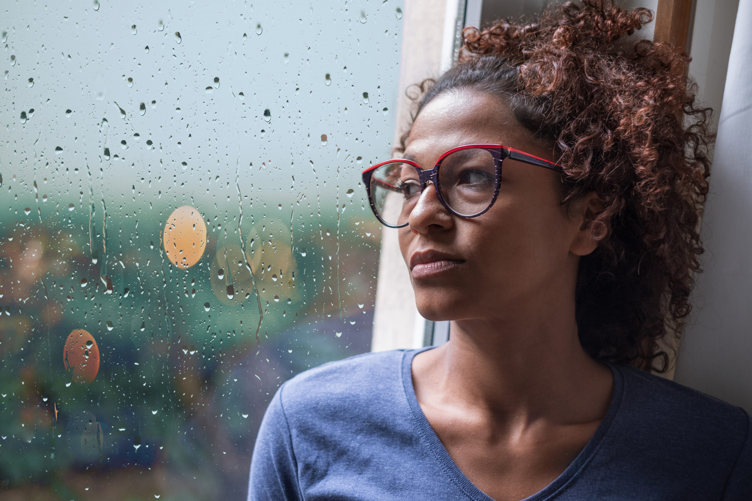 Woman looking out the window; managing stress and anxiety